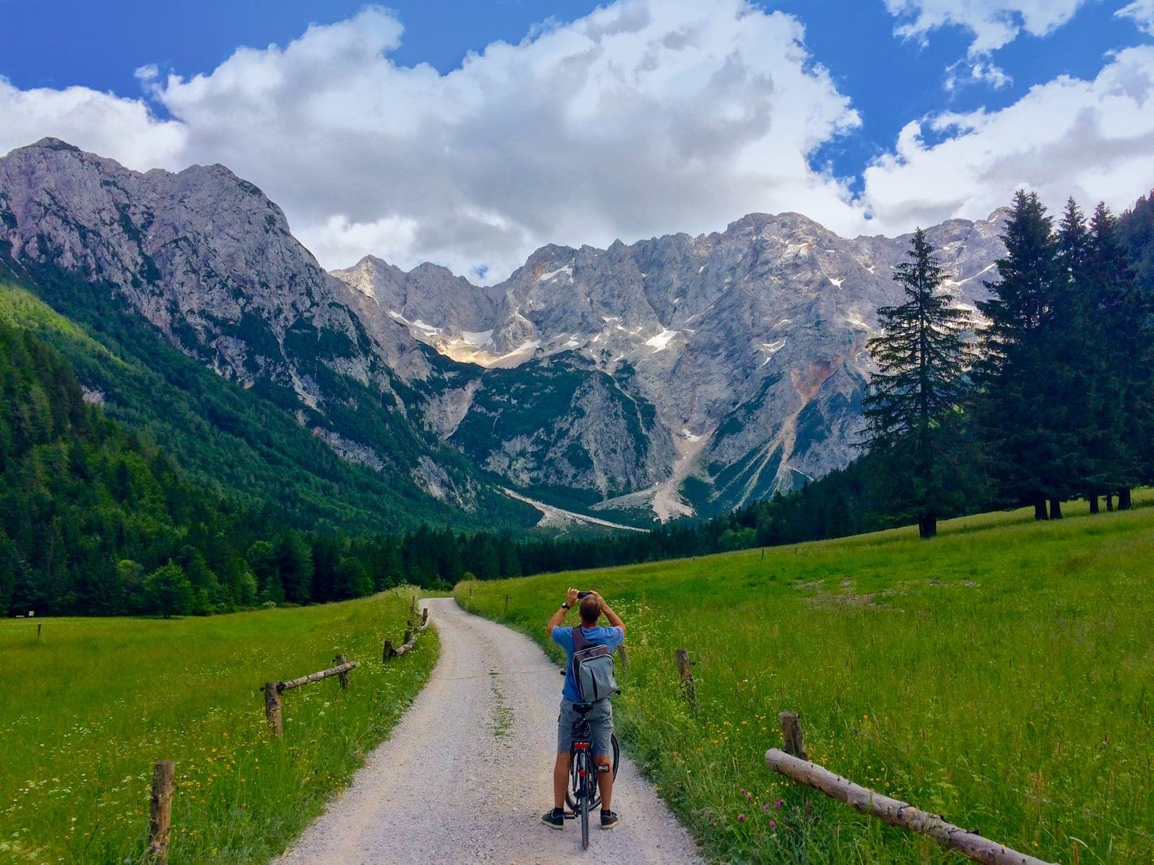 Cycling-in-Zgorne-Jezerco with mountains in the background and green meadows either side of the cycle path