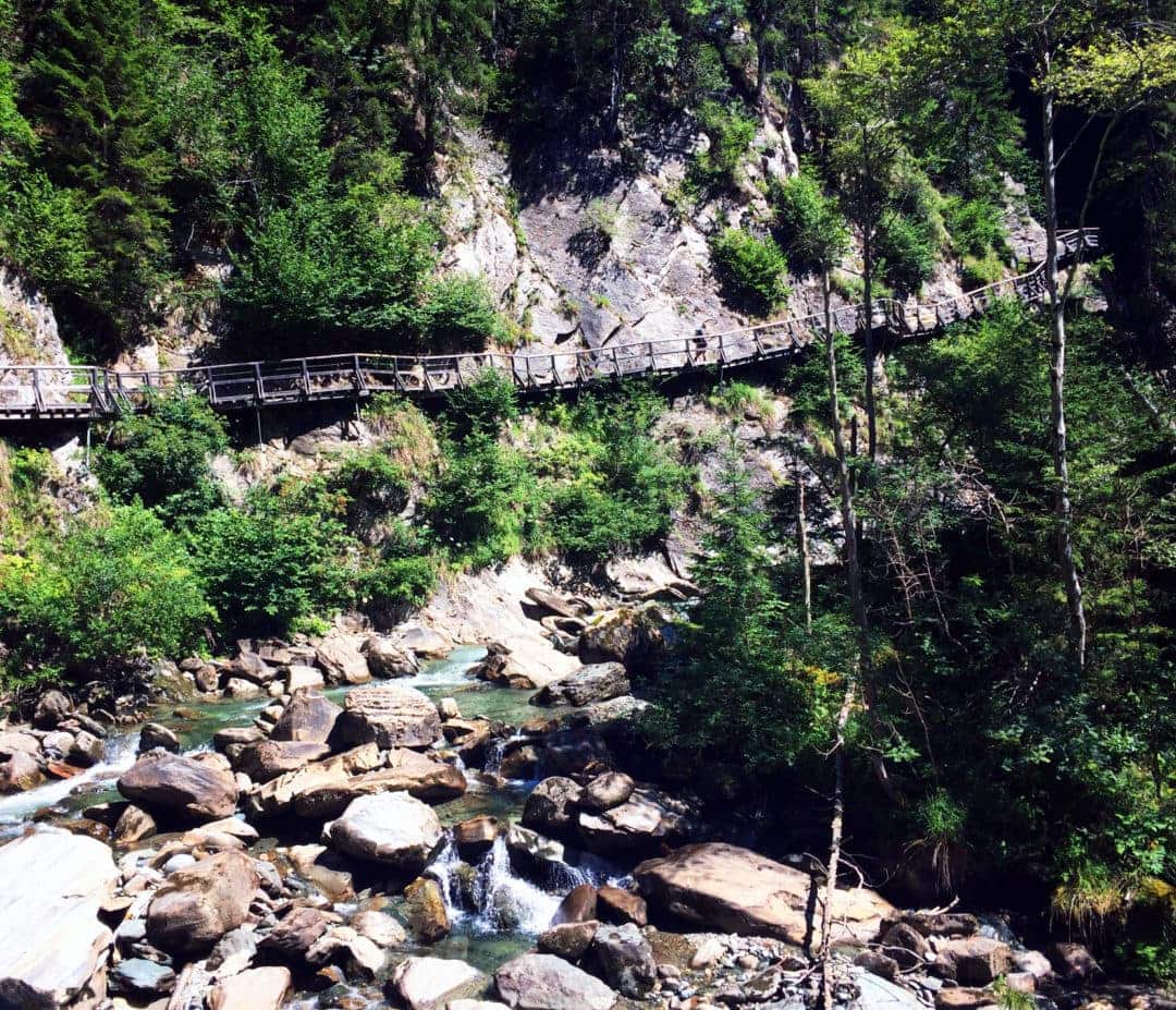 Gloppenstein-Waterfall-Austria a wooden bridge stretching over a stream 