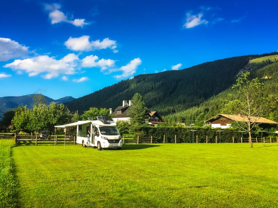 Gosauschmied-Motorhome-campsite with motohome parked in green field with Alpine mountains in the background