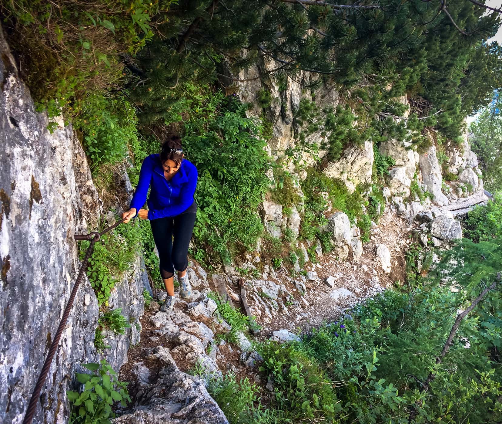 Hike-to-Ceska-Koca and SHelley holding on to a rail on the edge of a craggy rock face 