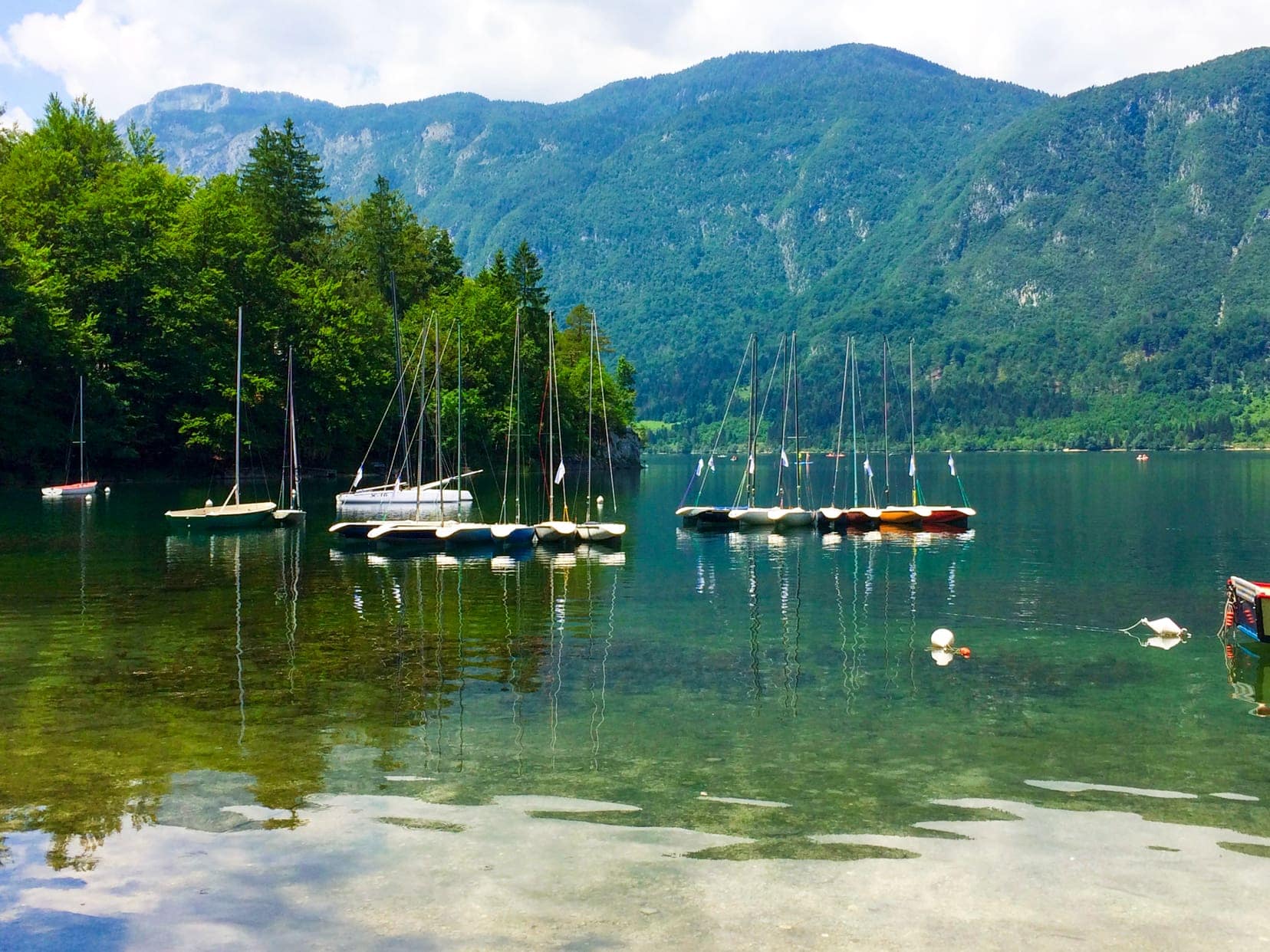 Lake Bohinje with a few small boats on teh blue green water