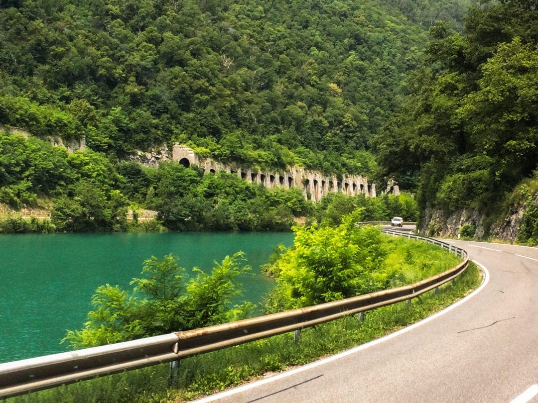 Road in Slovenia with green lake beside the road
