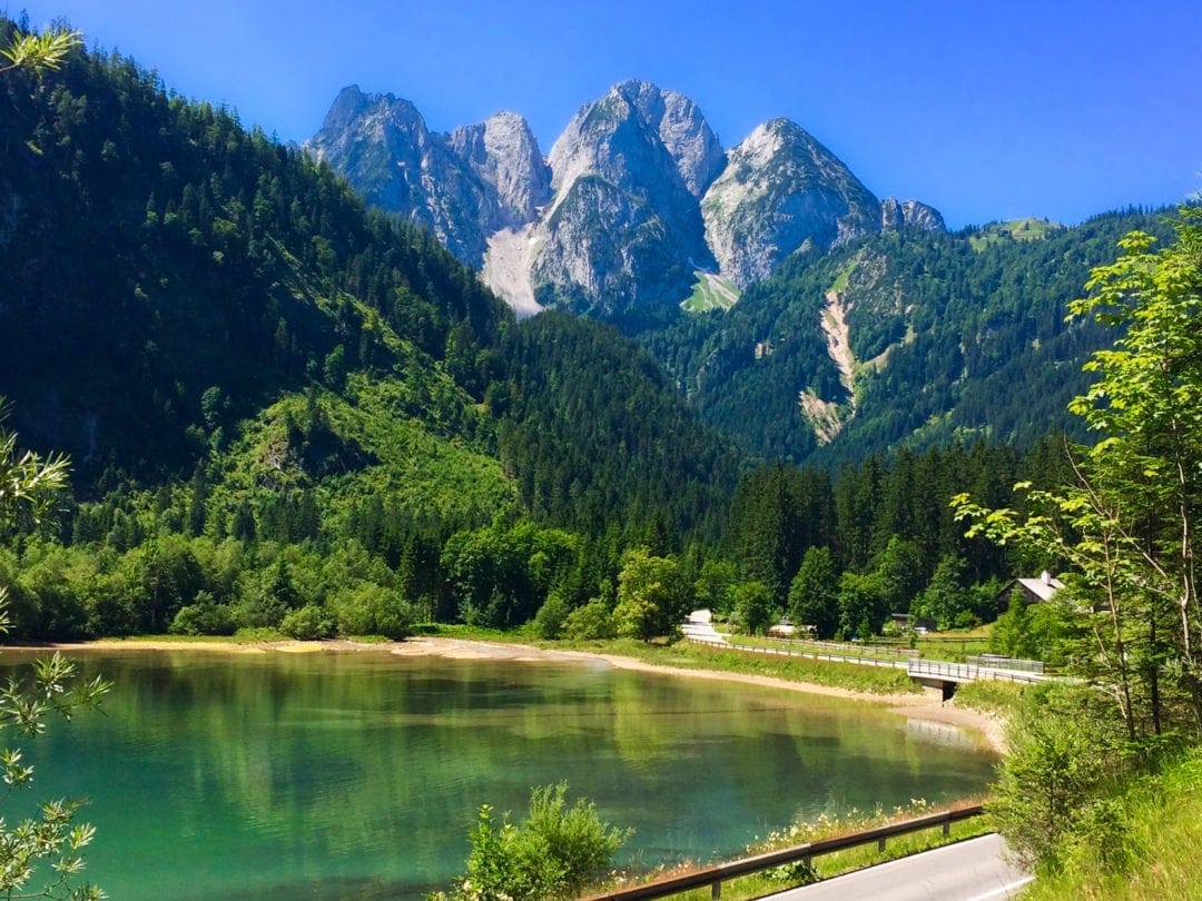 Scenery in Gosau - blue green lake with pine trees and mountains in the background