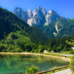 Scenery in Gosau - blue green lake with pine trees and mountains in the background
