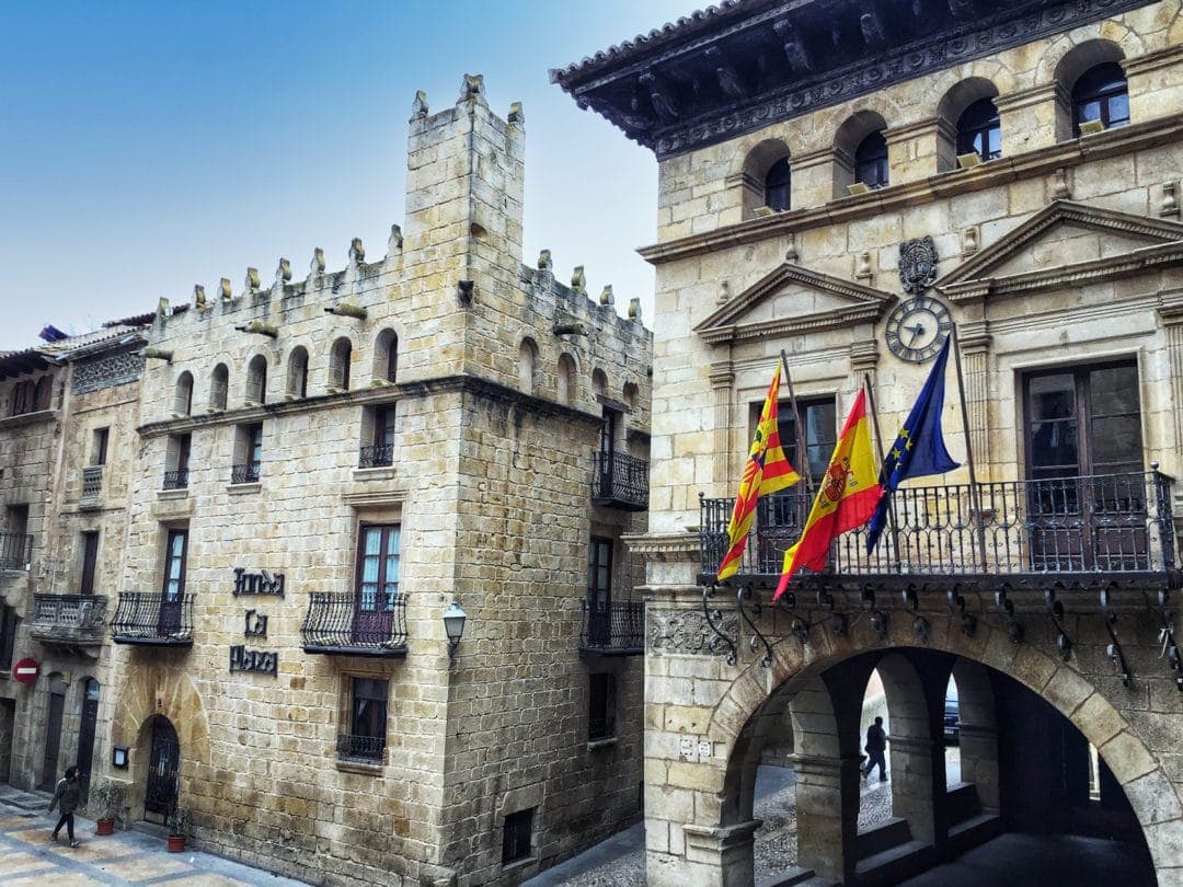 Grey stone buildings with the catalania flag flying 