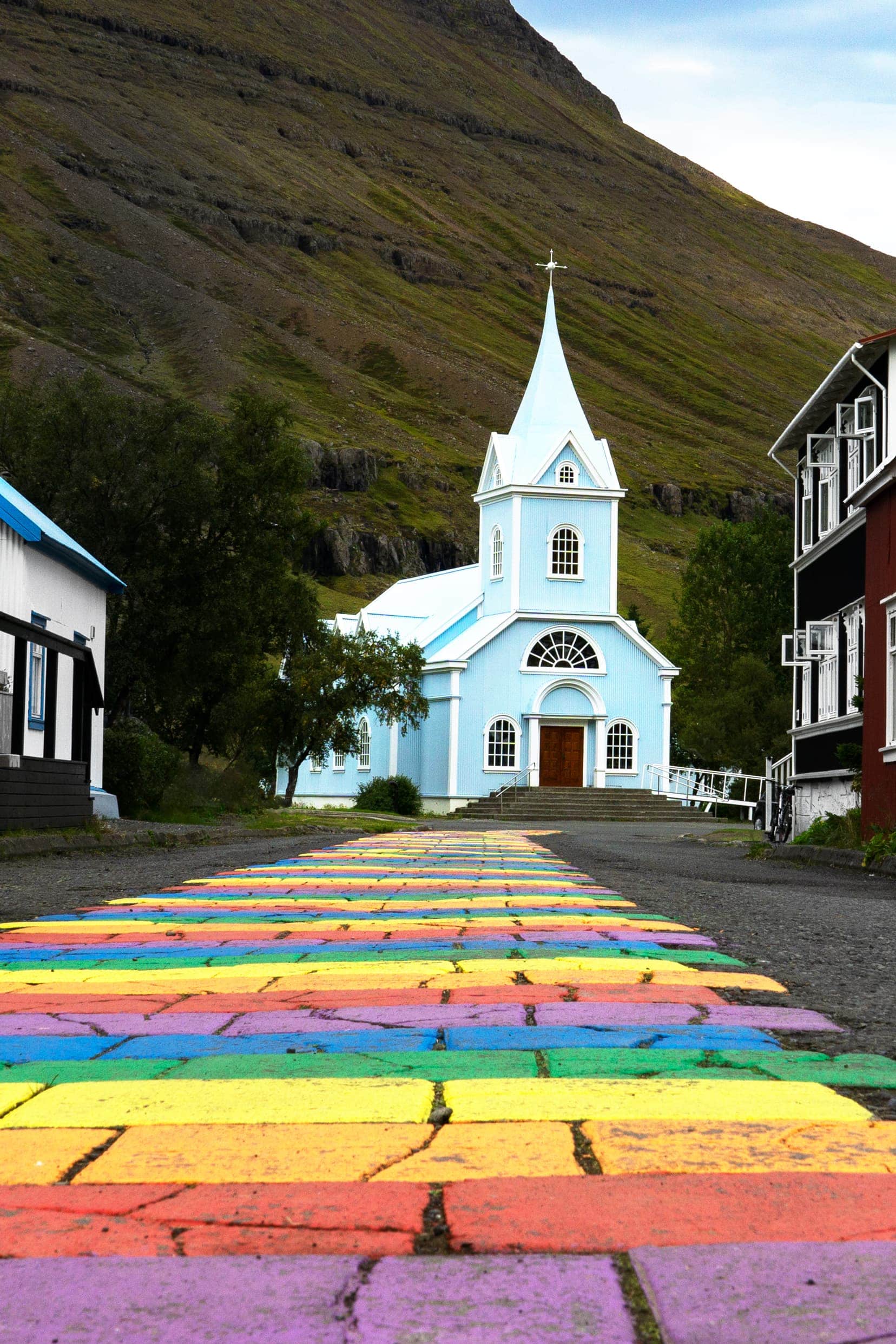 Blue church at the end of a rainbow path