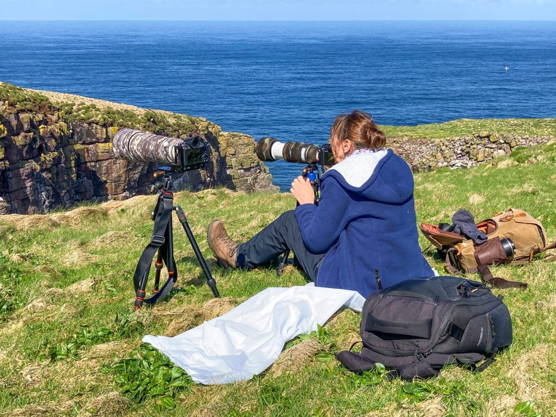 Shelley sat with camera on tripod opposite one of the cliffs 