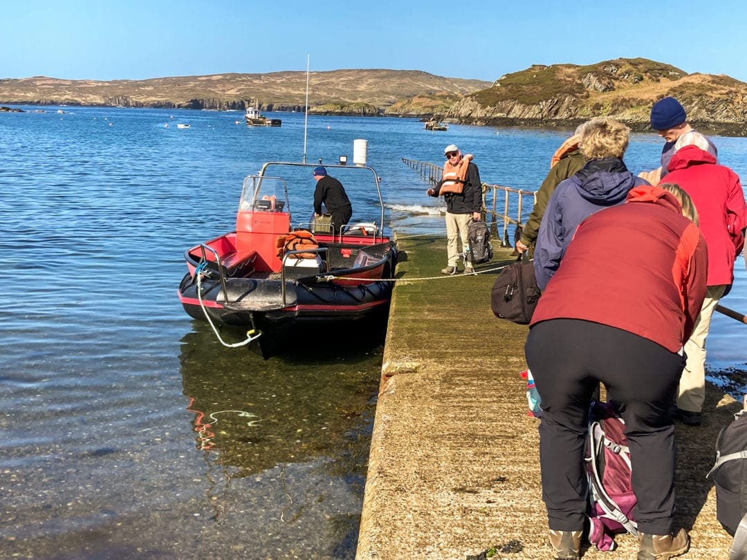 Tarbet jetty with people puttin gon lifejackets and getting ready to board the passenger ferry