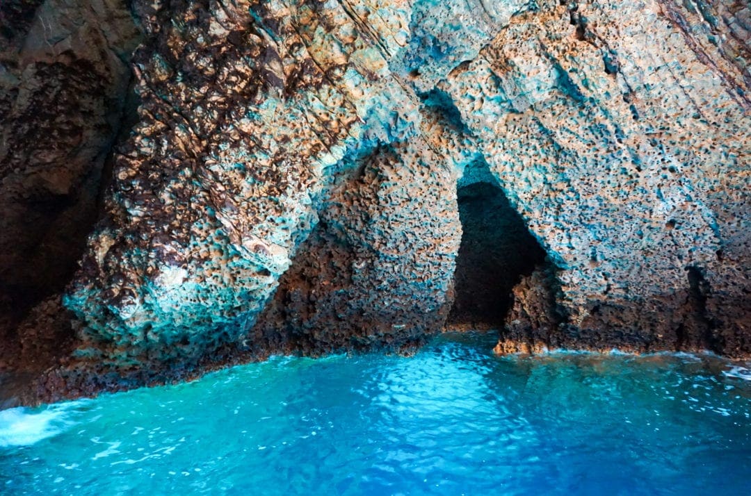 Blue grotto with turquoise blue water by cave walls