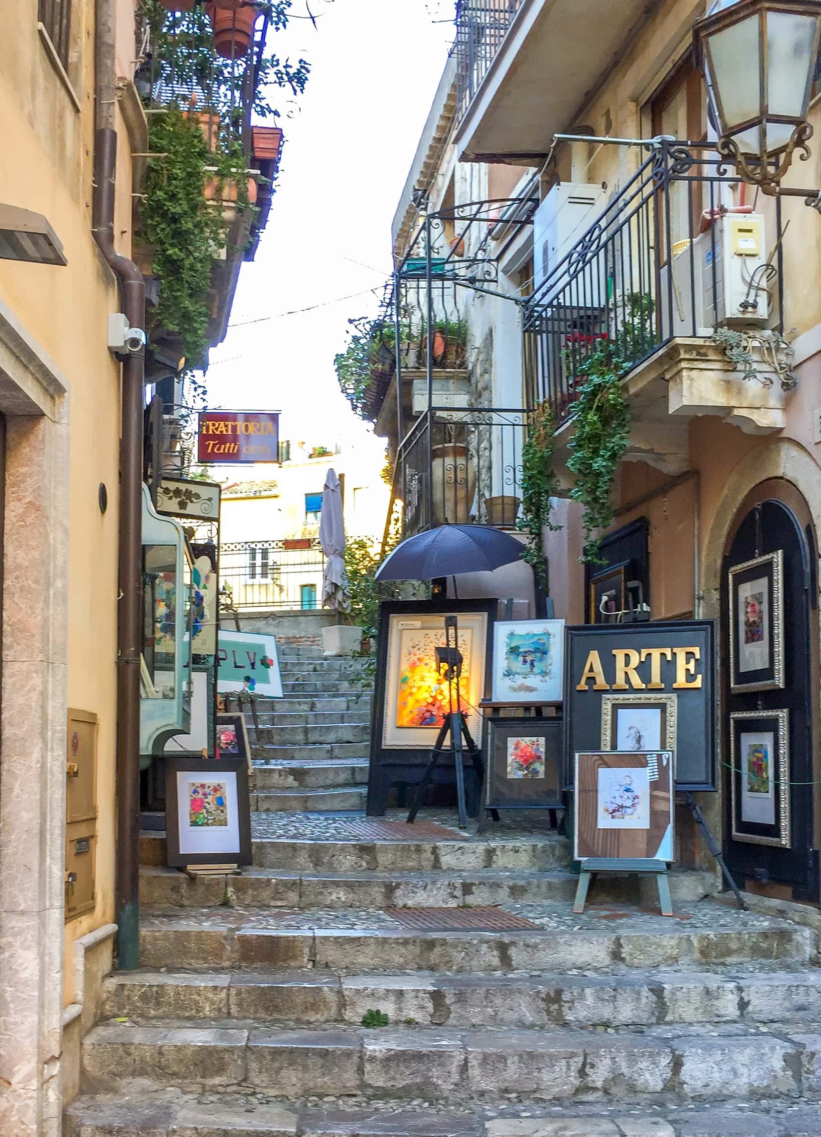 A side street showing art on the steps in Taormina