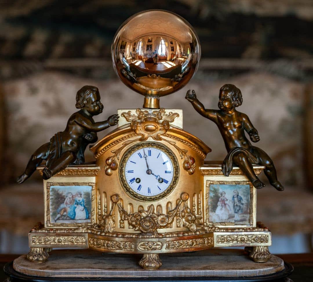 Dining-room-Dunrobin-castle - a clock with angels either side a a refective ball above in which you can see the dining room reflection