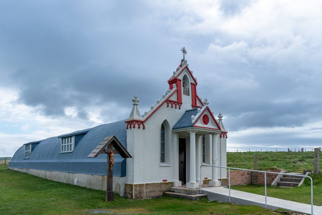 Italian church made of two nissen huts with red and white church like facade 