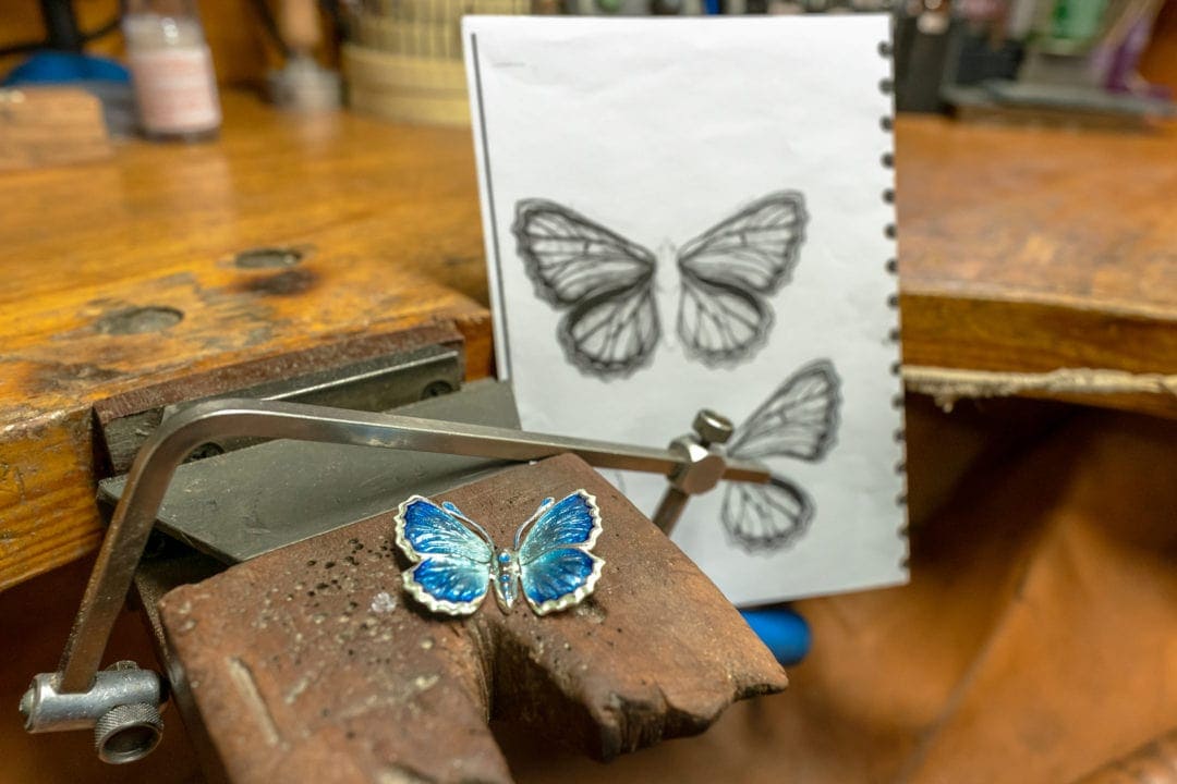 The design process of the jewellery showing a butterfly design drawing and butterfly 
