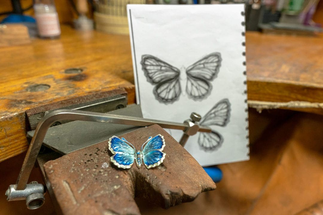 The design process of the jewellery showing a butterfly design drawing and butterfly