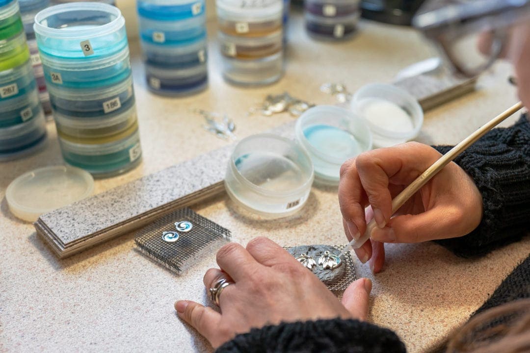 Adding enamel grain by grain to the jewellery