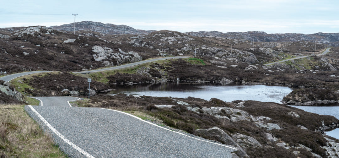 The-Golden-Road-Isle-Harris road through grey rocky landscape and a loch 