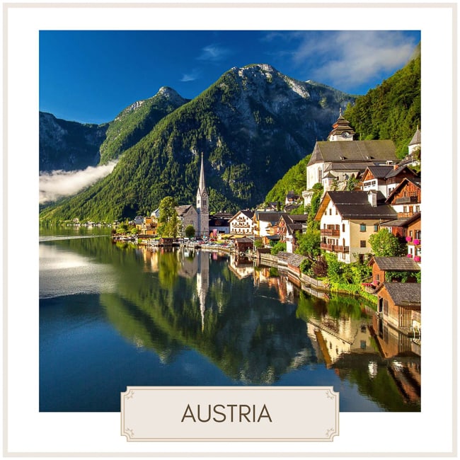 Destination Austria  - image of a villageon the edge of a lake with mountains in the  distance