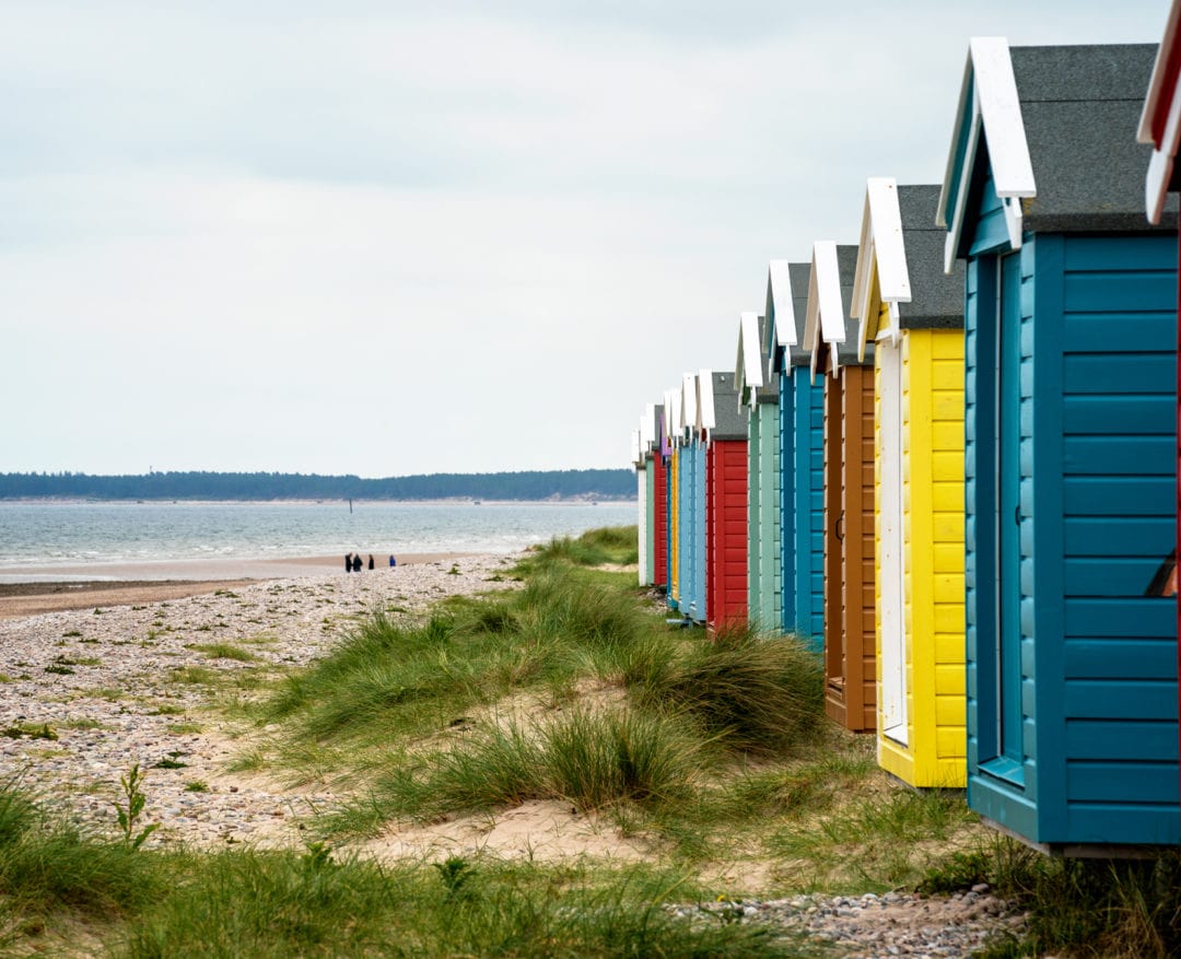 Coloured beach huts on a sandy beach 