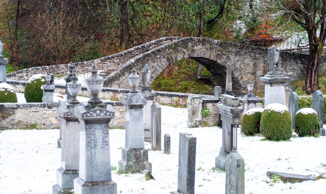 Keith old bridge viewed from the nearby cemetery with gravstones and snow in the foreground