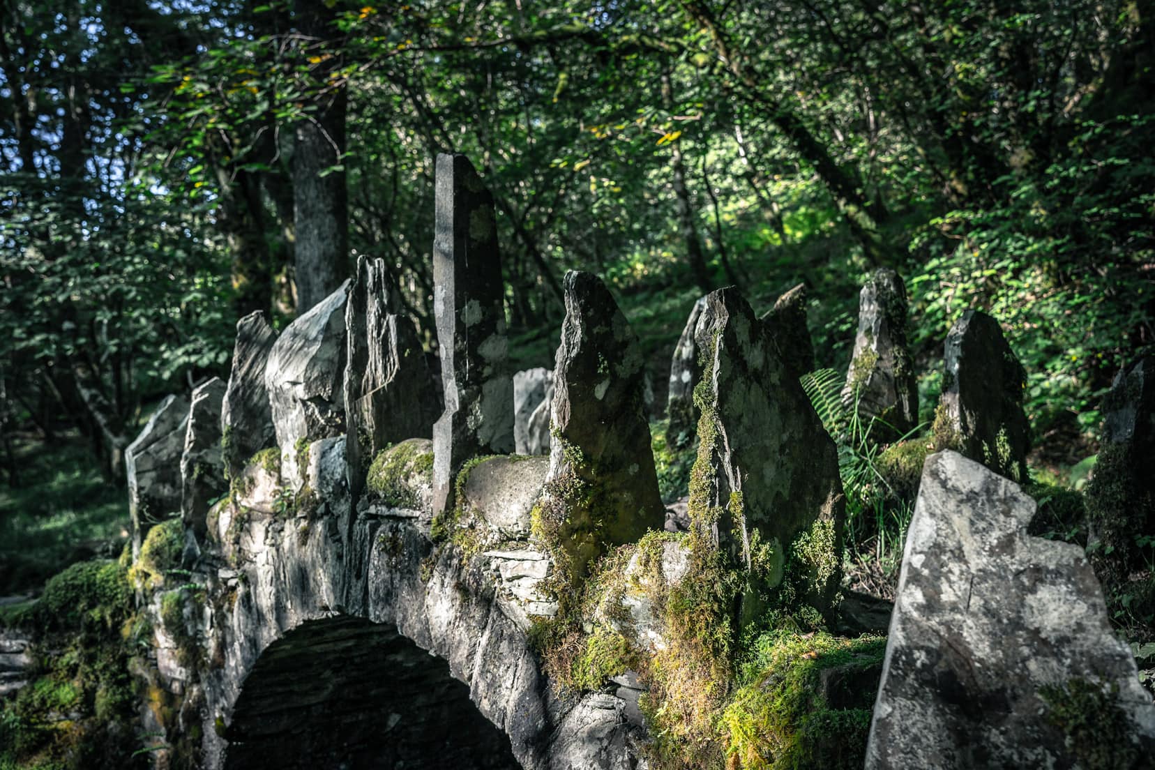 Fairy bridge of Glen Creran with pointed stones on its arch amongst woodland