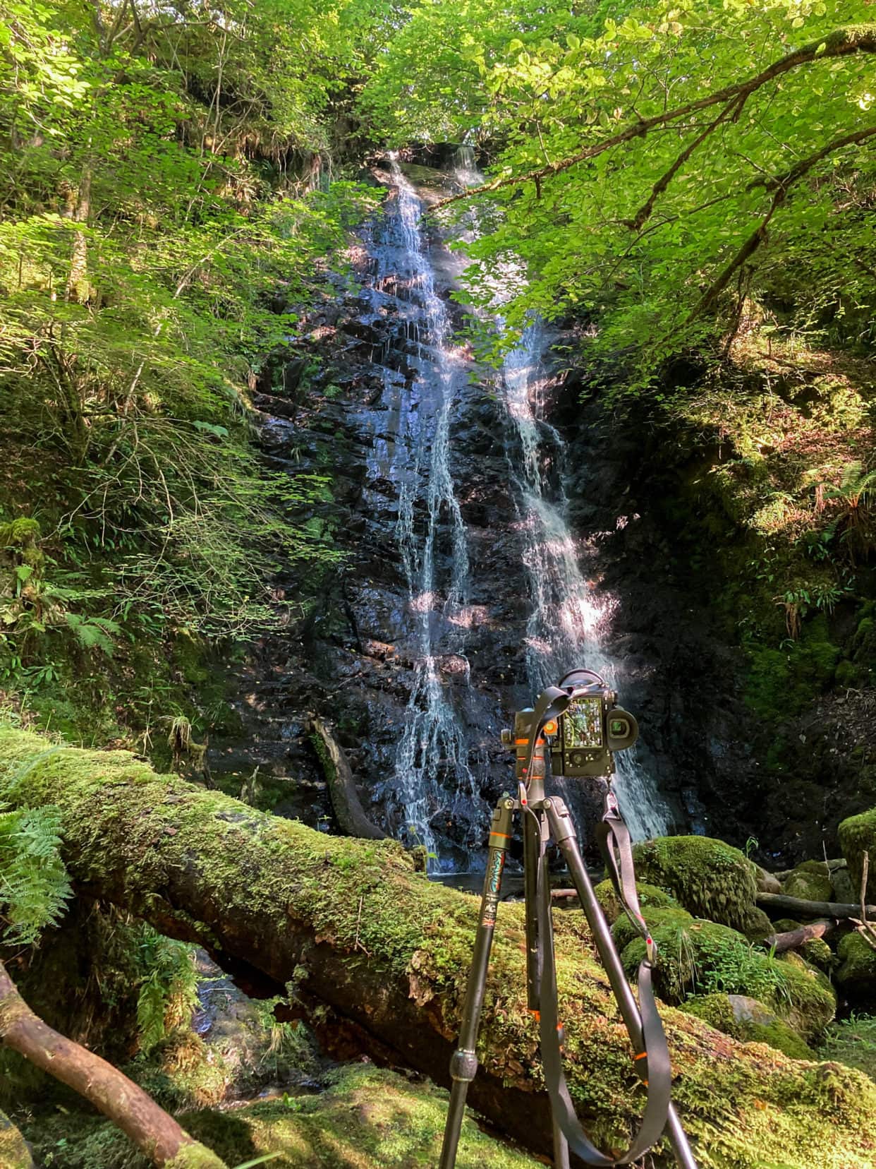 camera tripod set up to shoot a waterfall