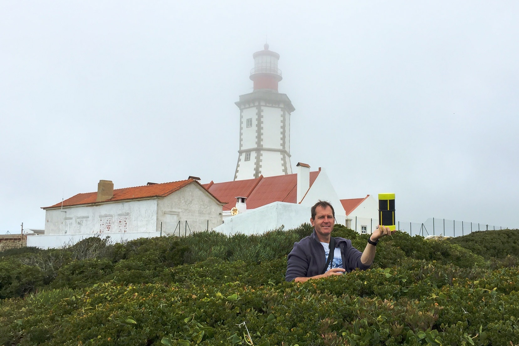 geocaching in the scrub with lighthouse  in a foggy background