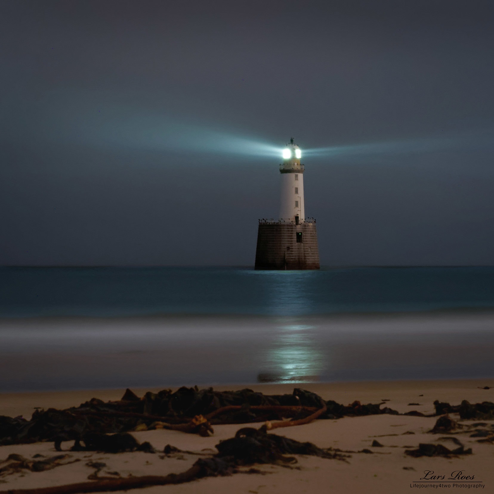 lighthouse seen at night with its light on