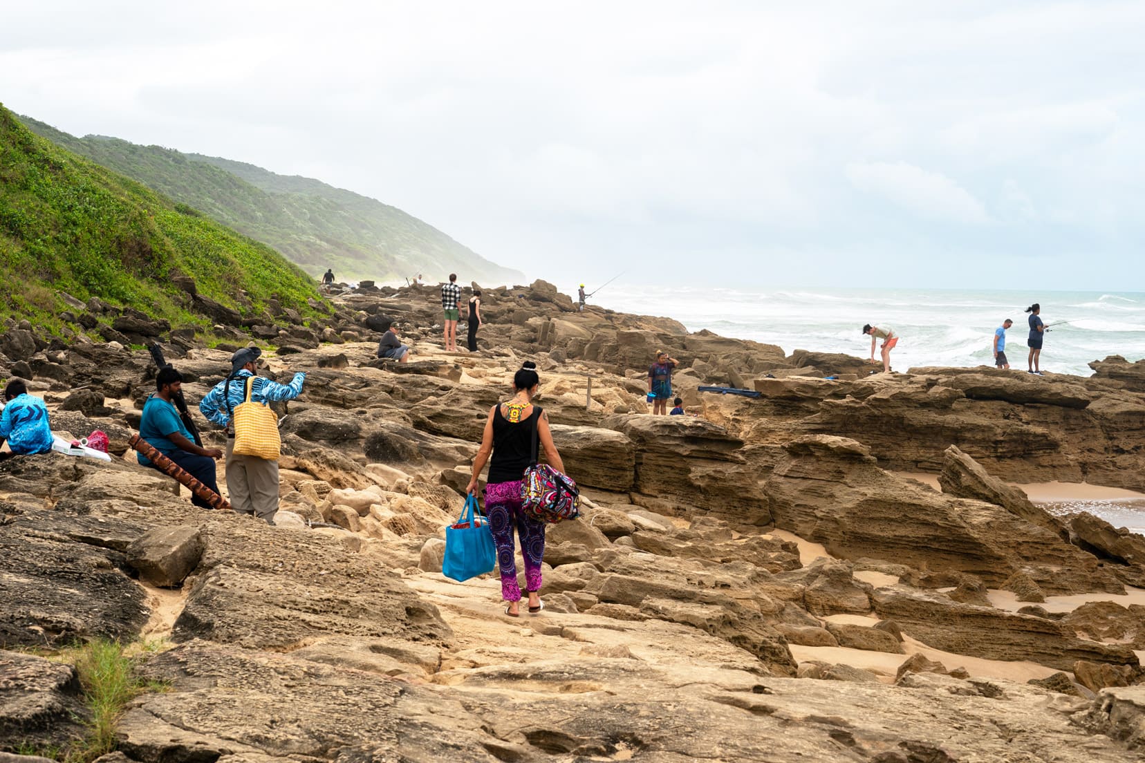 mission-rocks-isimangaliso-Wetlands - rock shore line with people fishing and carrying picnic bags