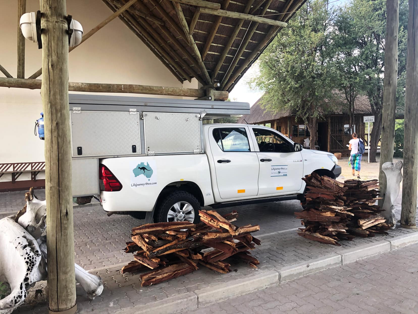 Our camper parked at the first gate - with piles of wood stacked beside it and an office in the background.