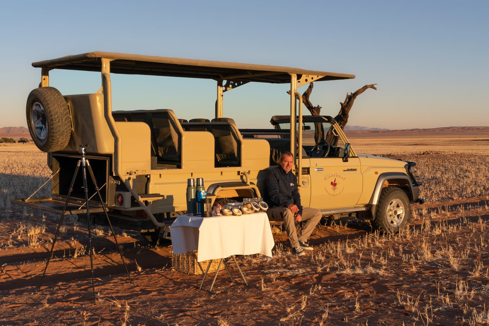 lars sat by table by guide vehicle on a sunrise driving tour at Kanaan desert retreat