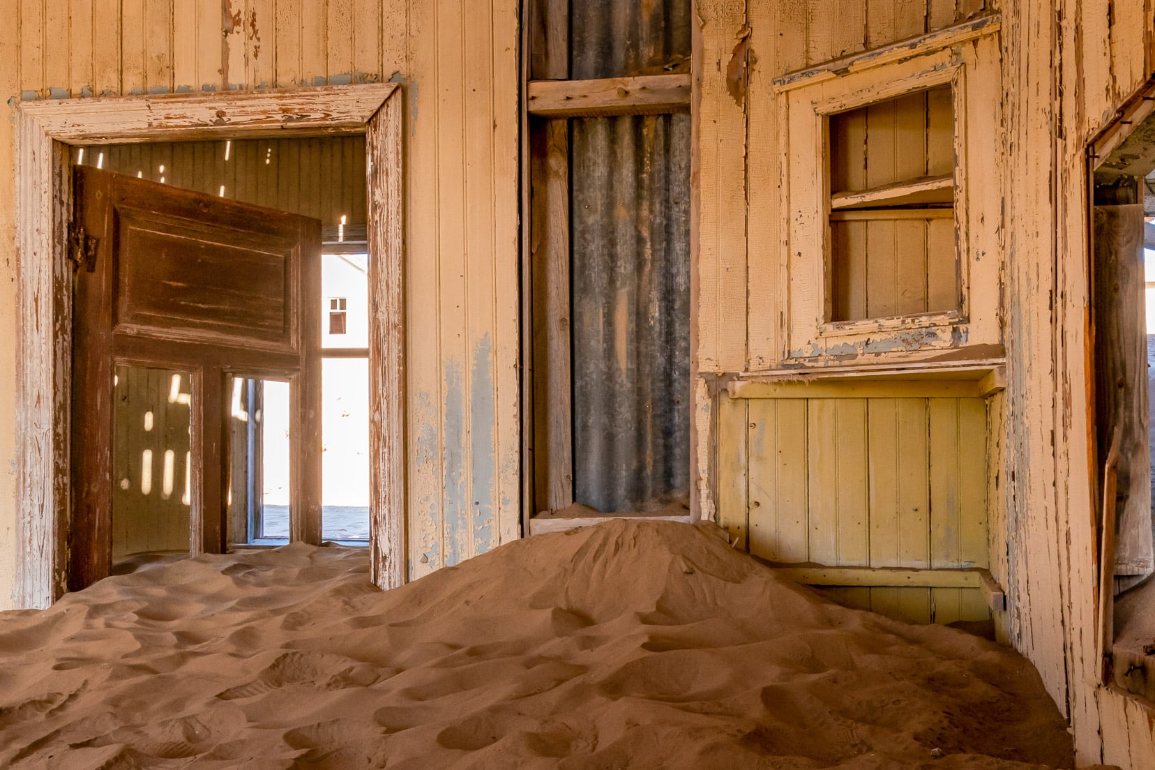 Room in Kolmanskop ghost town filled with sand 