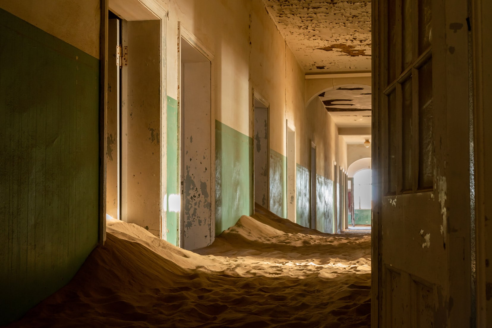 Kolmanskop Ghost Town hospital corridor with sand filling the doorways
