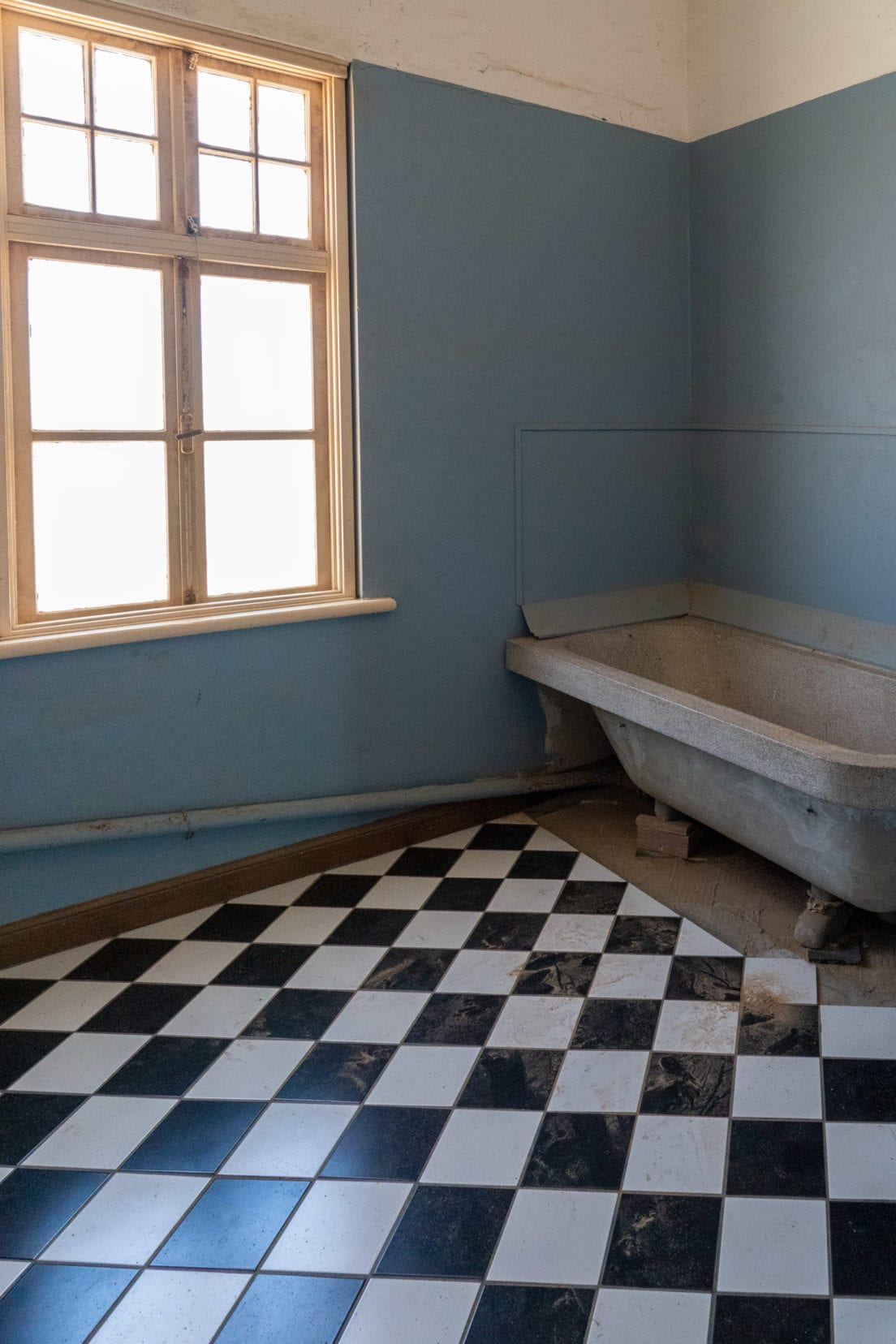 expensive black and white tiles imported from Europe on the bathroom floor and an iron bath