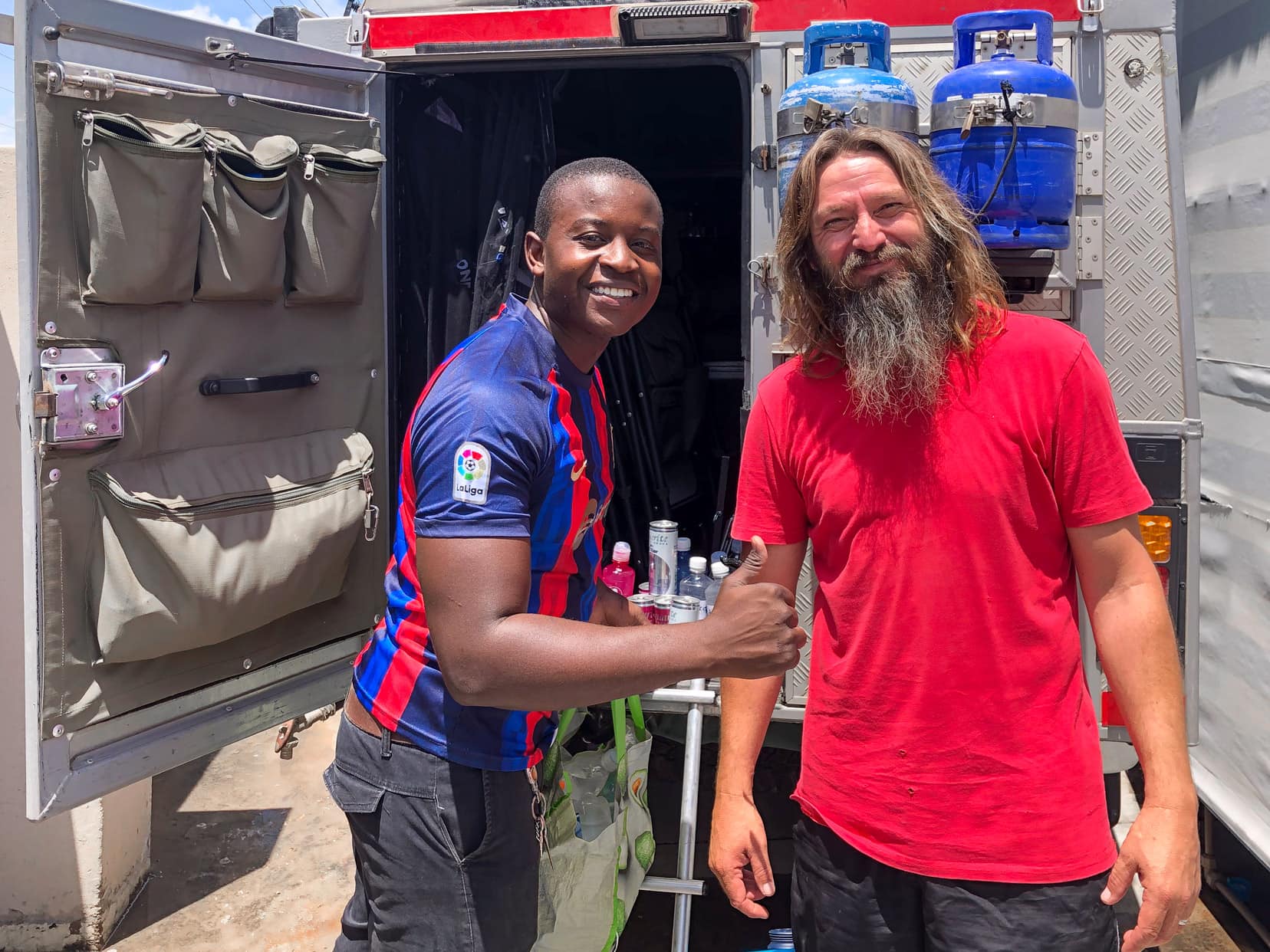 2 men loading water into the back of a 4x4 in Botswana