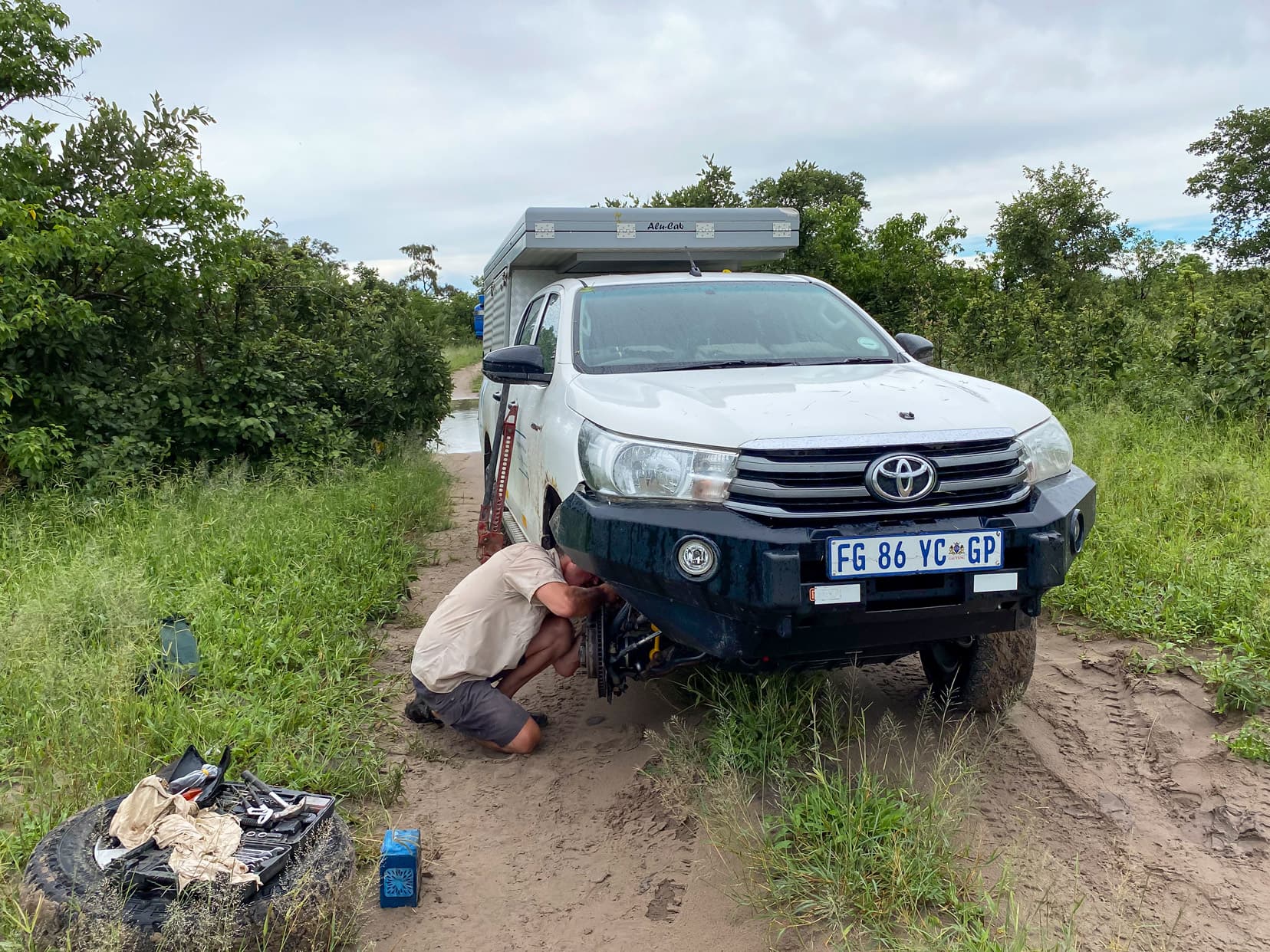 Our-Hilux-4x4-undergoing-some-bush-maintenance-by-myself beside a flooded road