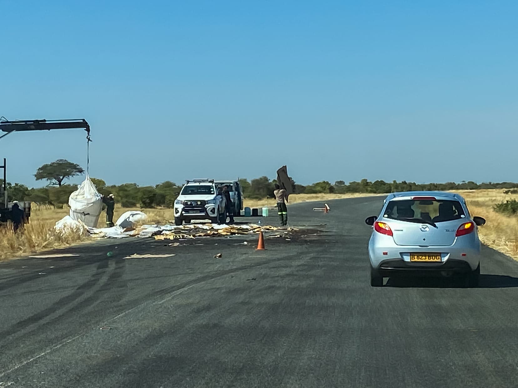 car using hazard lights whilst going around dropped objects on a road