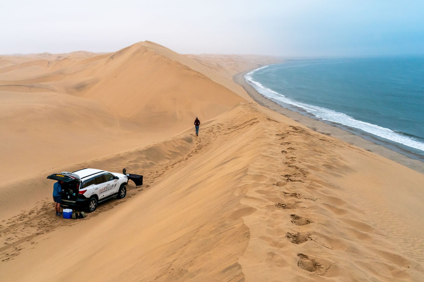 early-morning-fog-with a car-parked-up-in-dunes overlooking the sea