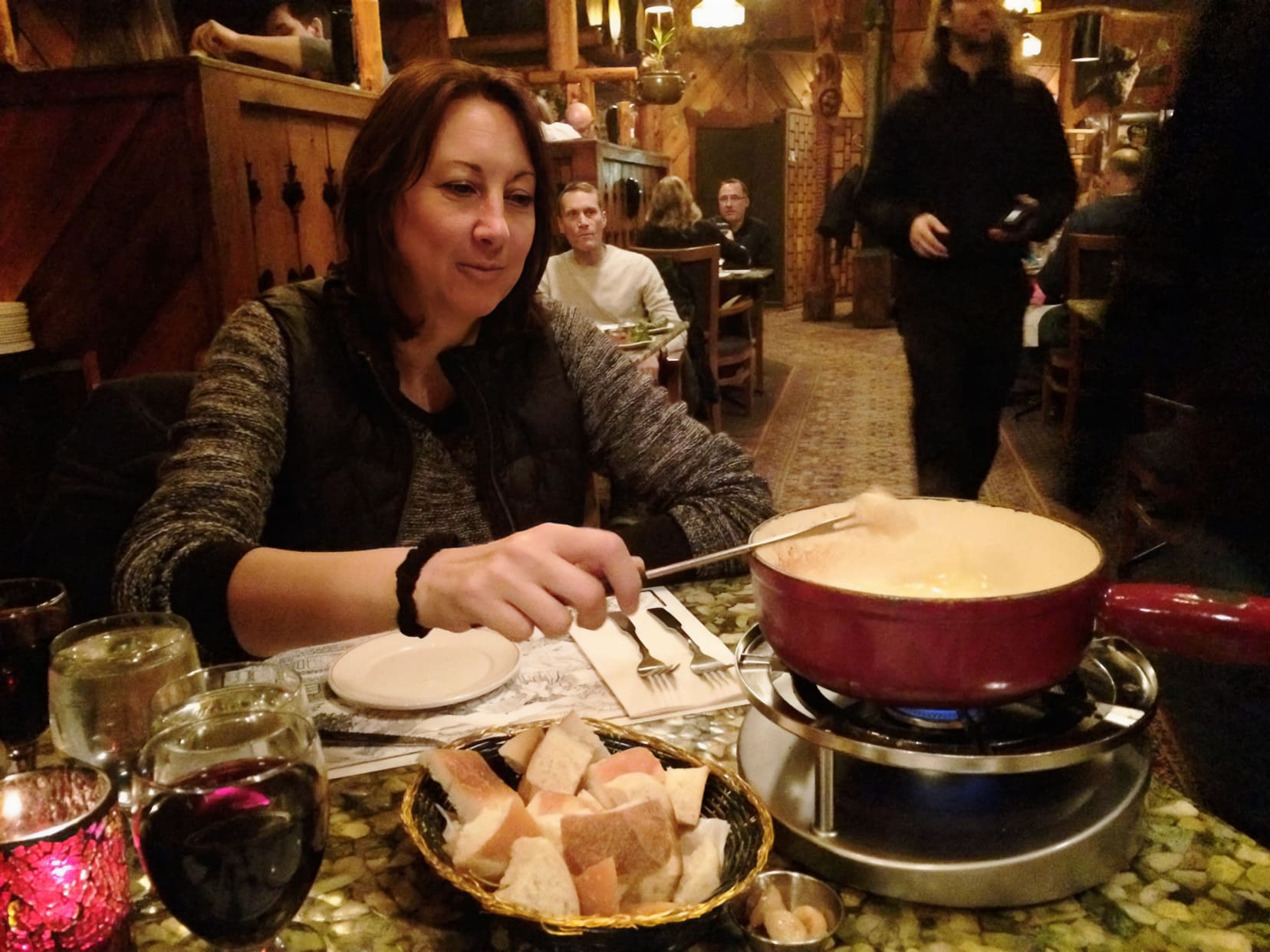 Shelley dipping bread into a cheese fondue at the Grizzly house in Banff