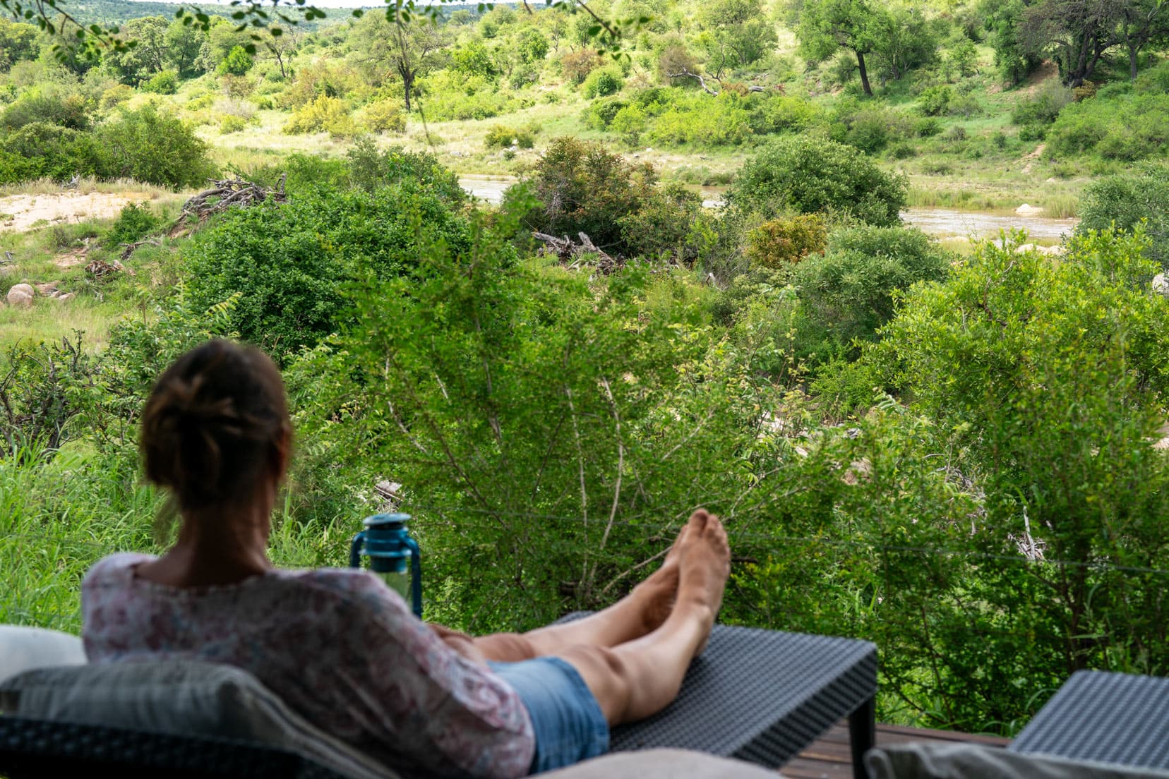 Shelley sat on a lounger at Ivory Wilderness Lodge, looking out over the Klaserie River and african bush