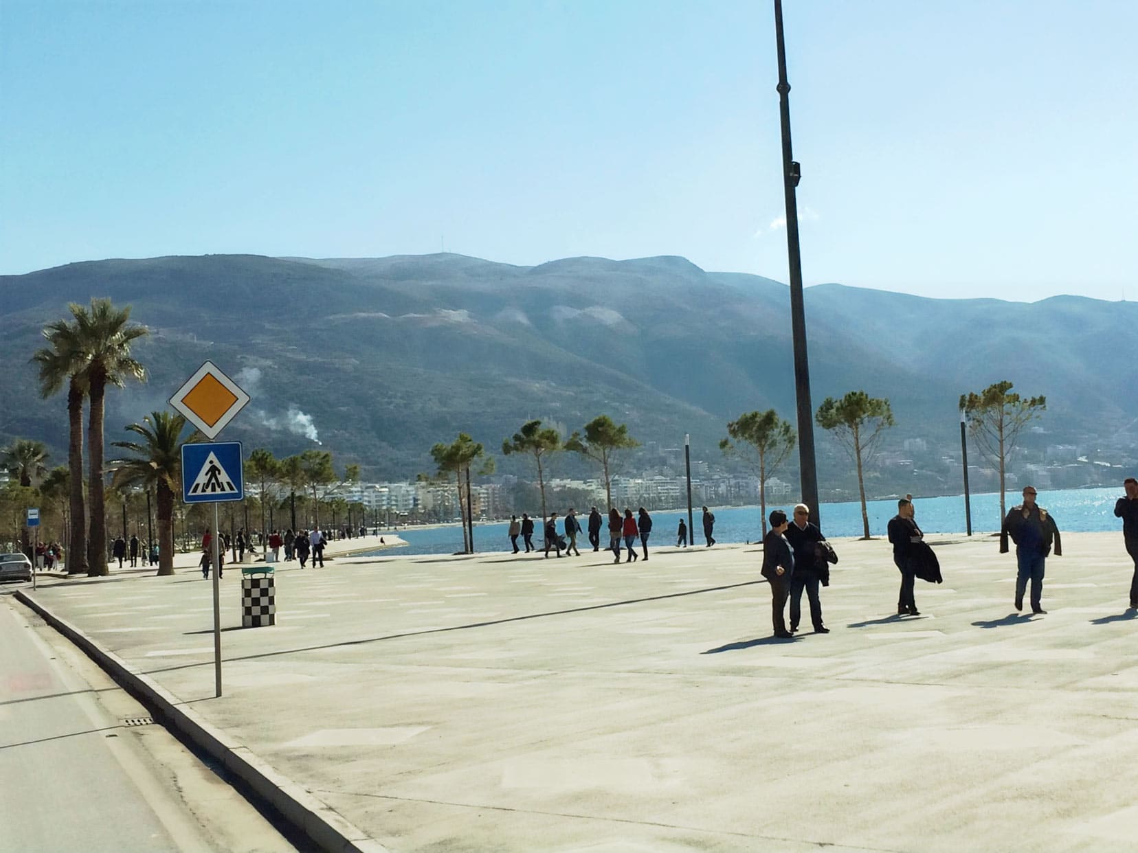 Pedestrianised wide paved area by the sea with people strolling