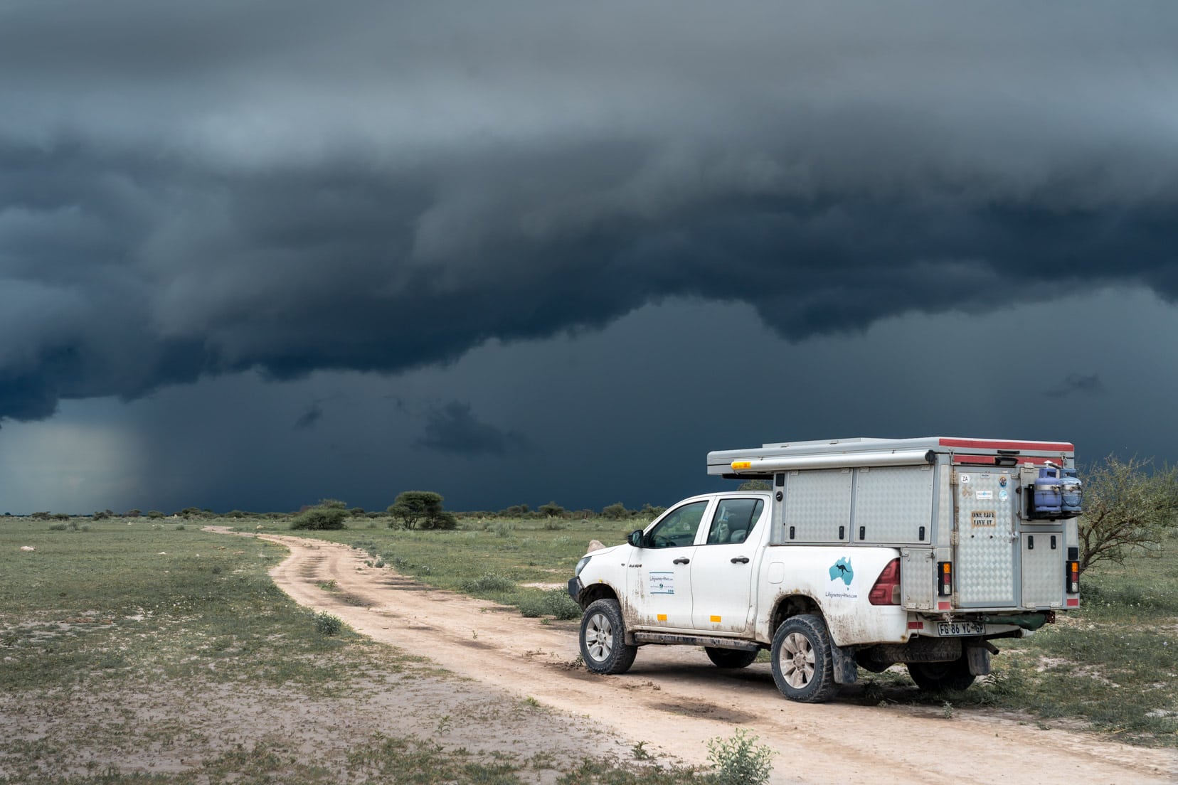Our Camper on a safari track with black thunderstorm clouds across the sky
