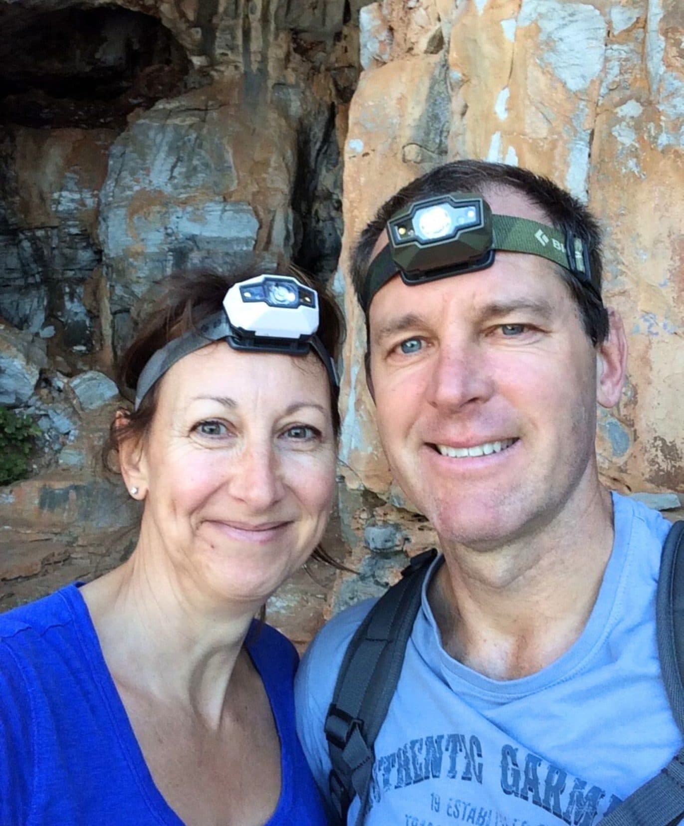 Shelley and Lars wearing head torches and stood by an entrance to a cave