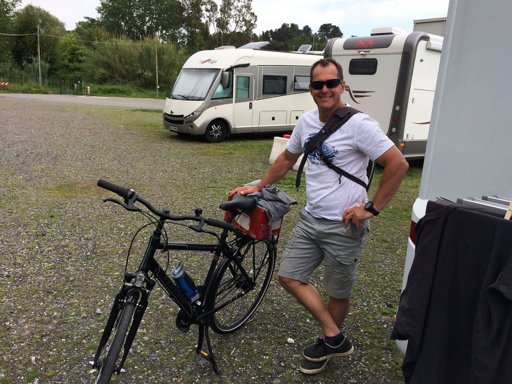 Lars stood by motorhome holding a bike