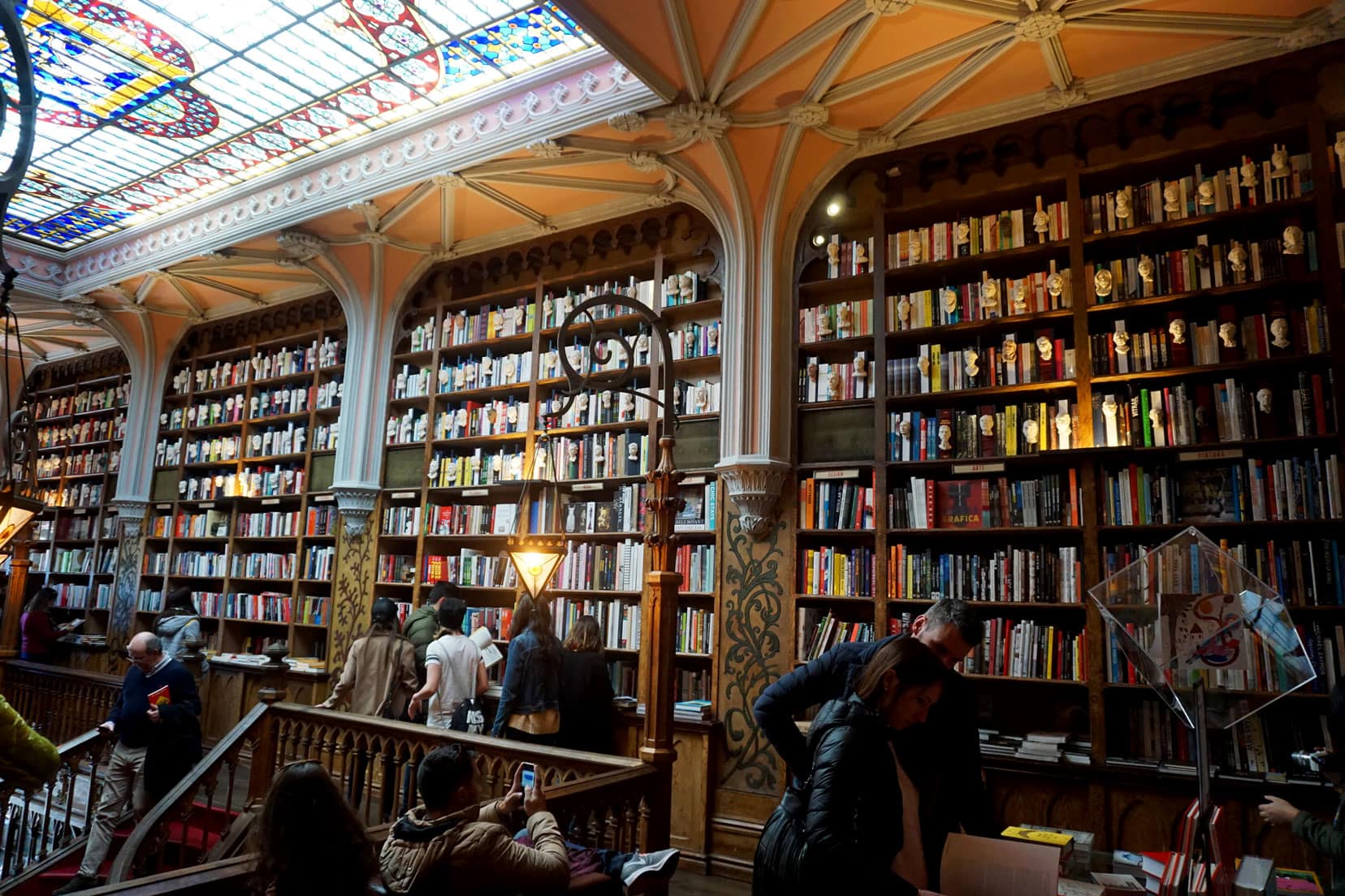 floor to ceiling book shelves in the Livraria lello bookshop in porto surrounded by decorated and carved altraves