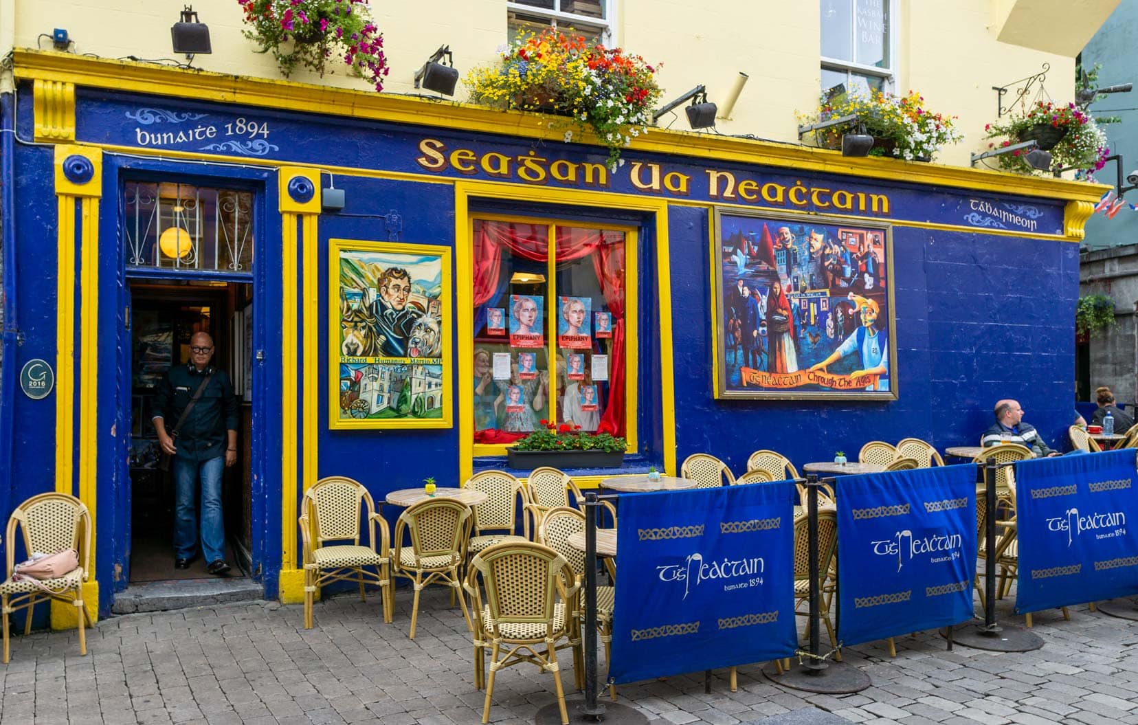 Galway Pub brightly painted in blue with murals and flowers on the outside