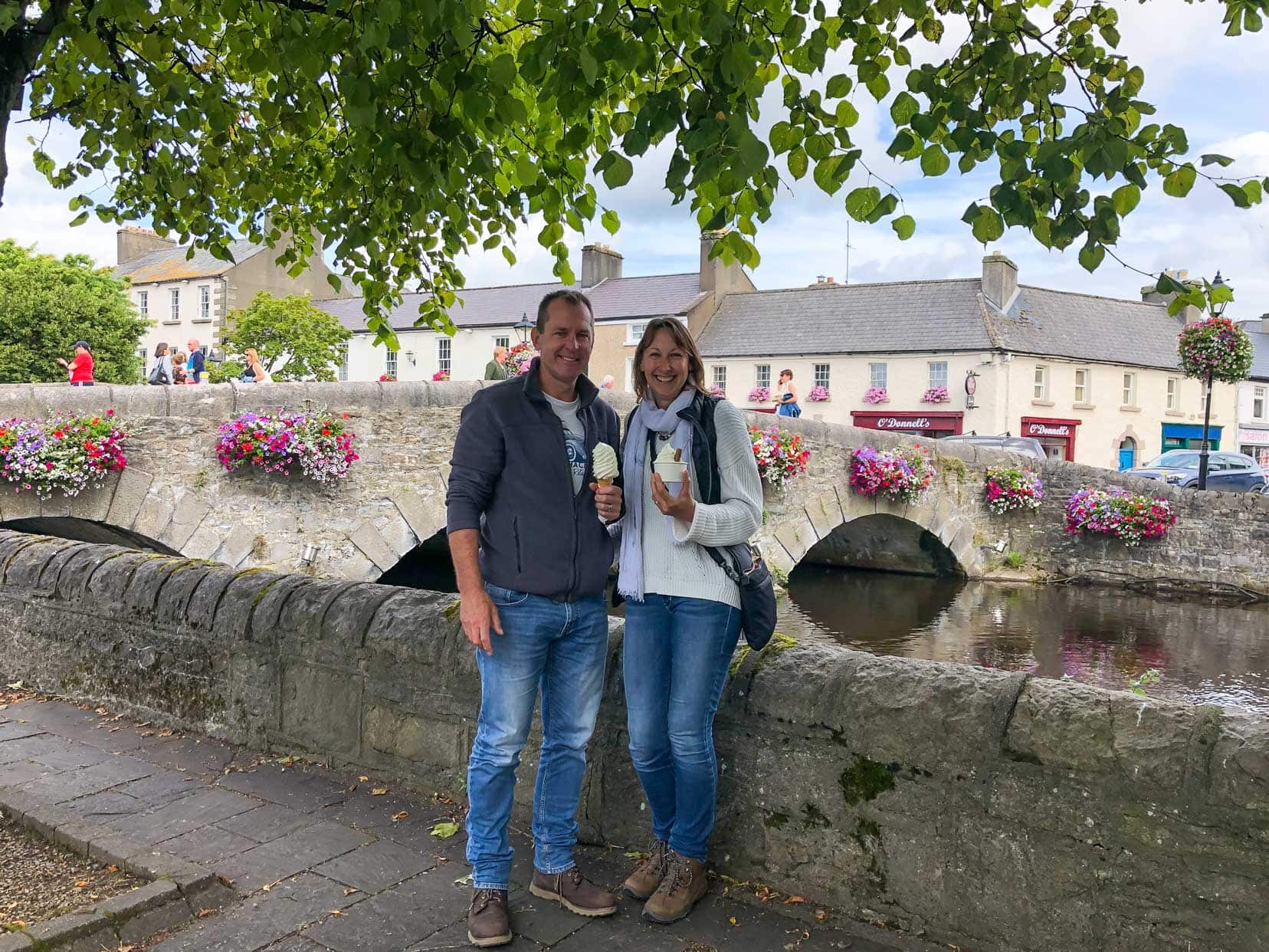 Westport-us-having-ice-cream_stood by a wall next to the river and a bridge with flower displays