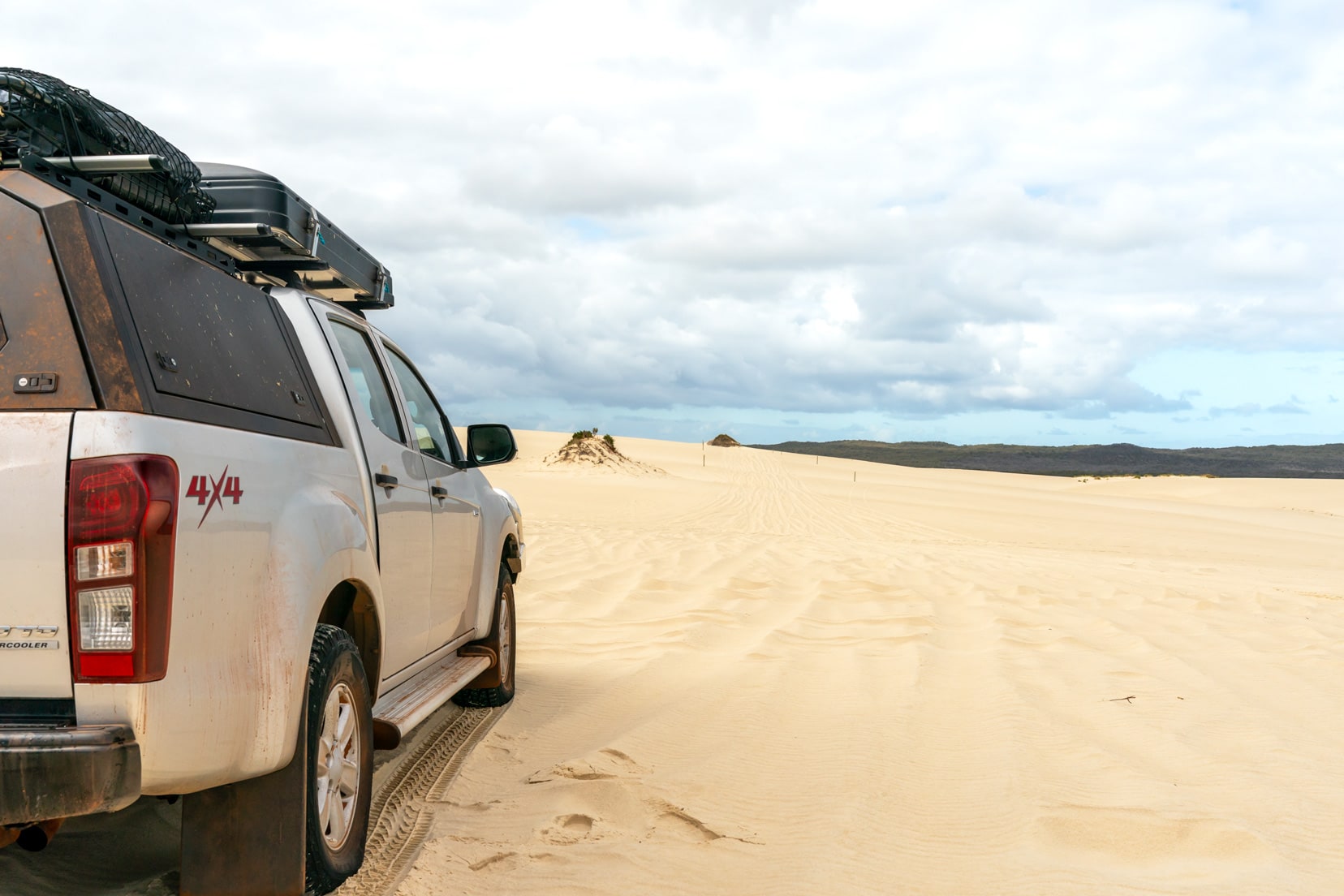 The side of our car on the left of the image and on a huge sand dune