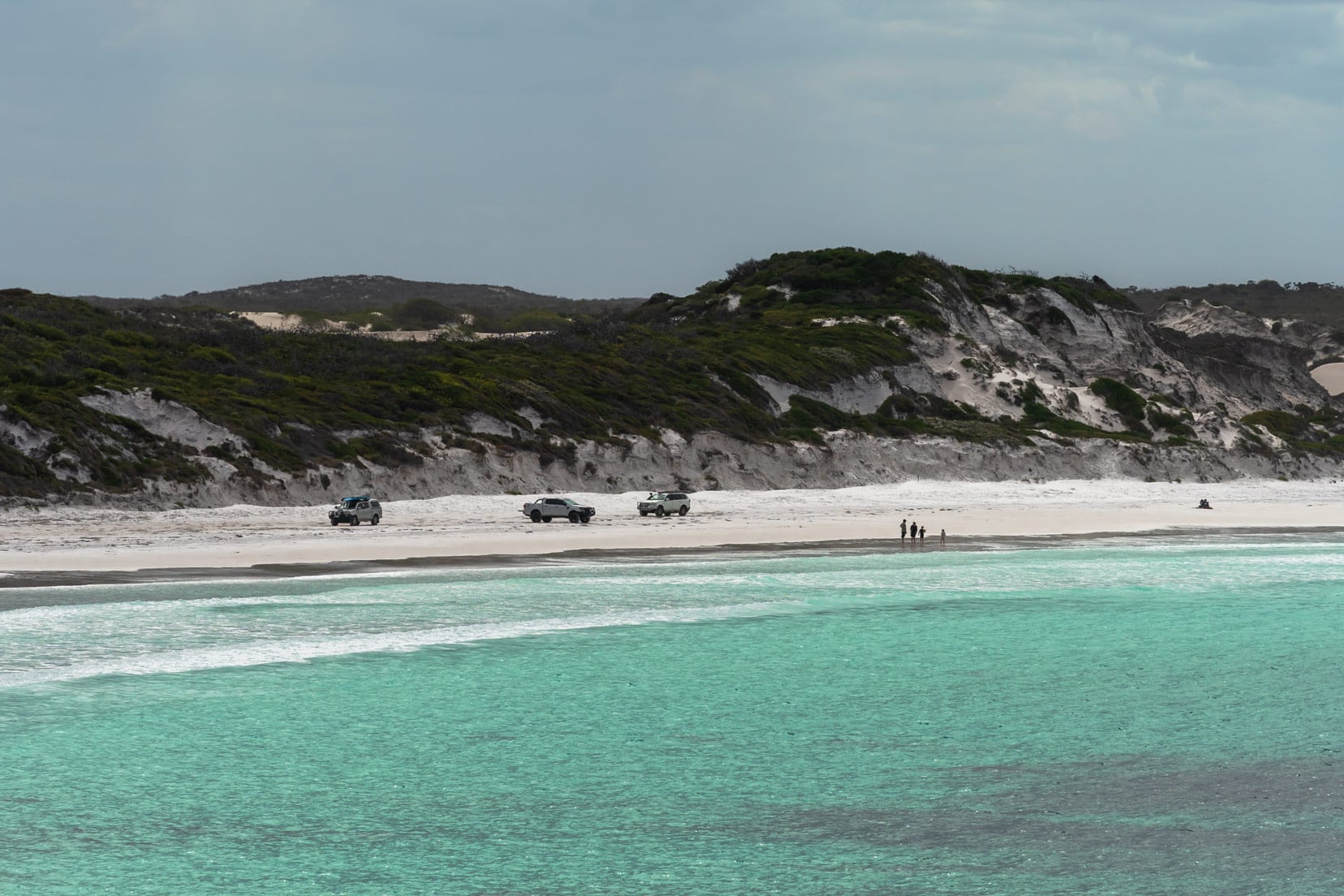 View of Lucky Bay Beach with four wheel drives on the beach