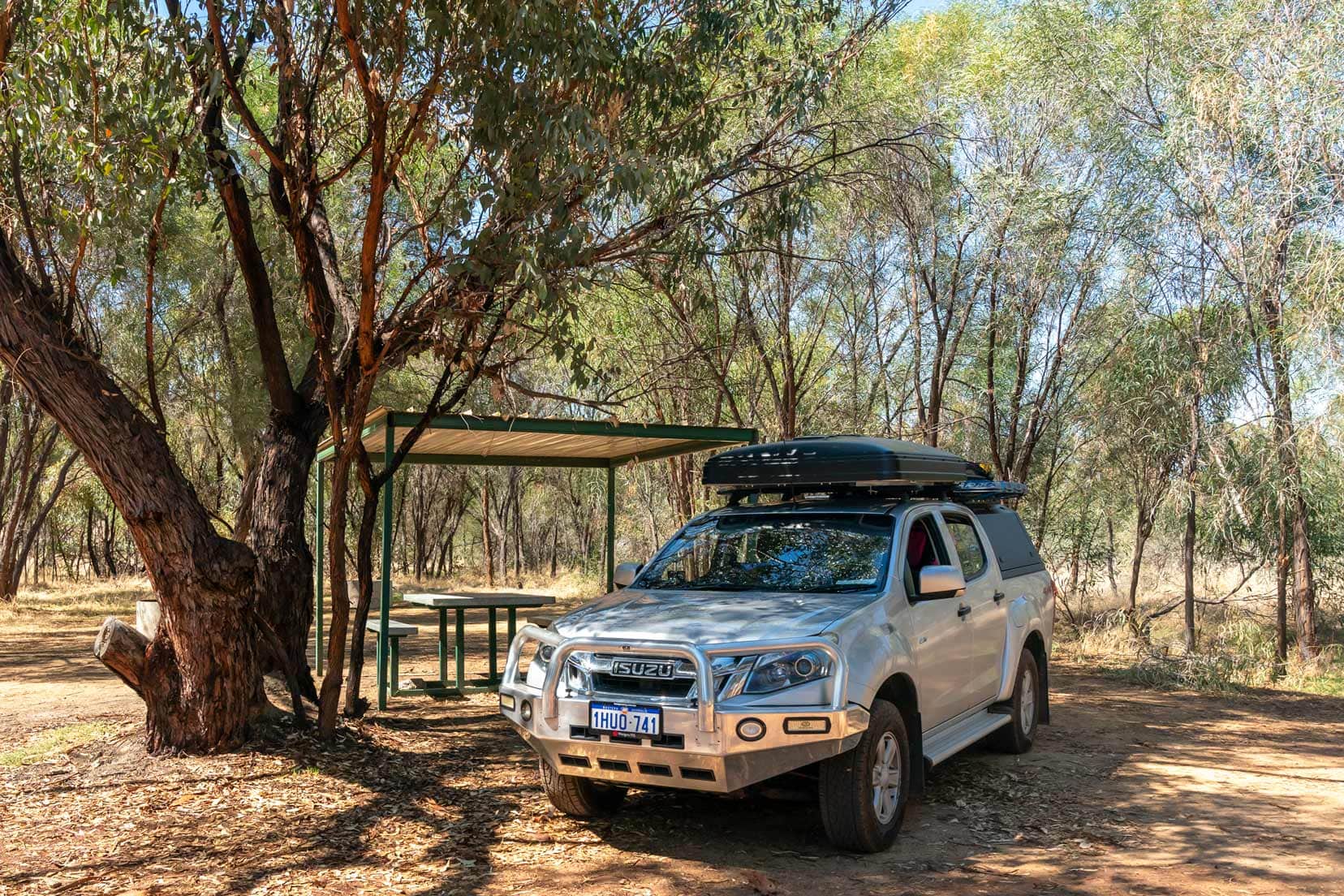 Quairading---Toapin-Weir our Isuzu Dmax parked in the camping spot with trees and a shelter behind