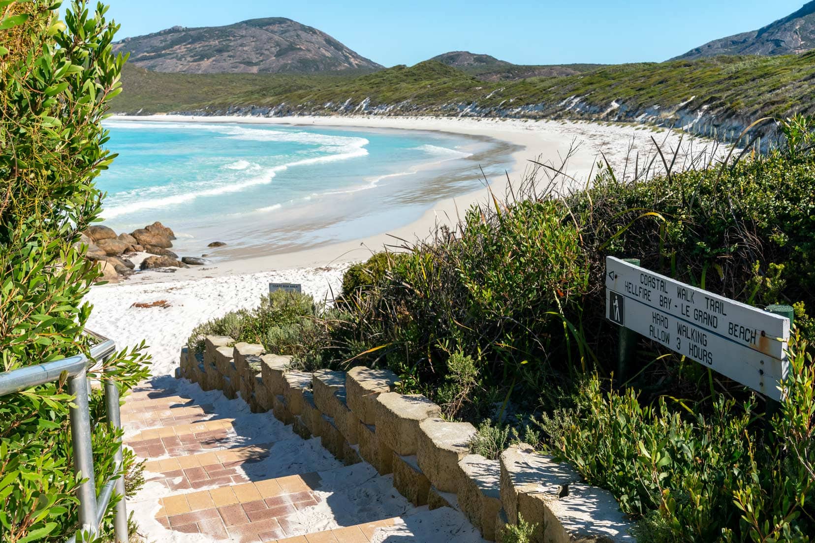 Stone steps leading down to white sand beach and turquoise ocean